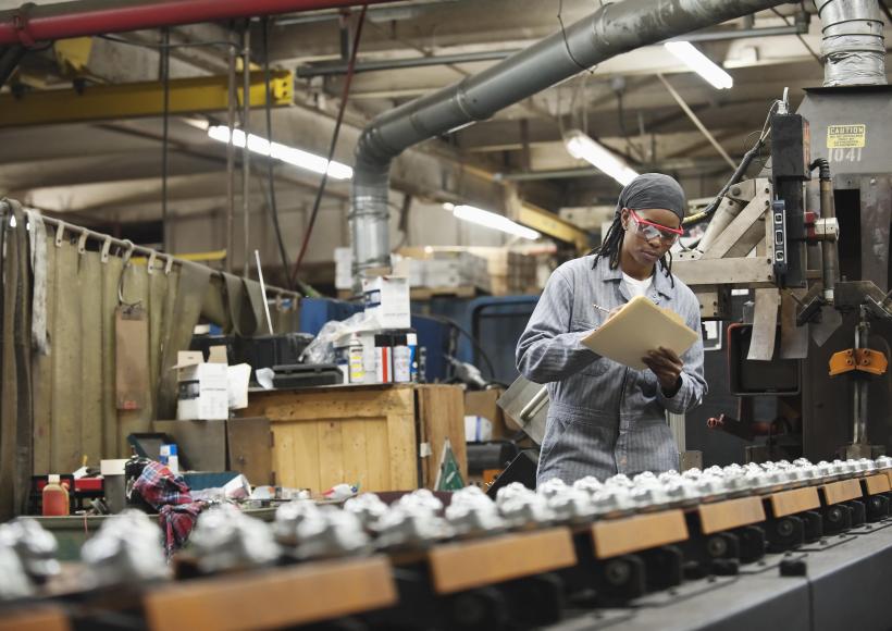 wide view of person writing a clip board regarding the manufacturing of products